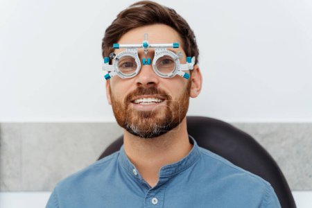 Téléchargez les photos : Homme heureux fabriquant des lunettes de test ophtalmologiste avec cadre d'essai. Soins de santé, médecine, concept humain - en image libre de droit