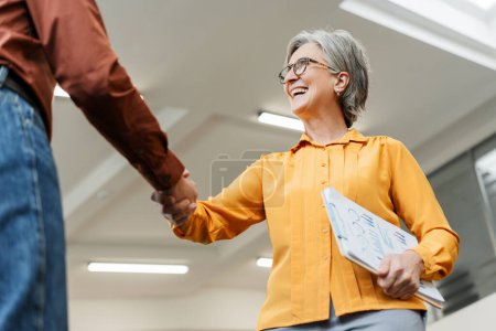Photo for Team smiling confident business people hand shaking working together in modern office. Meeting, teamwork, successful business. Job interview concept - Royalty Free Image