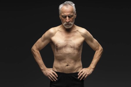 Photo for Portrait of pensive senior retired man with gray hair shirtless with closed eyes standing isolated on black background. Healthy lifestyle concept - Royalty Free Image