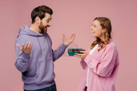 Photo for Attractive happy couple holding gift box celebration birthday isolated on pink background. Dating, love, Valentines day - Royalty Free Image