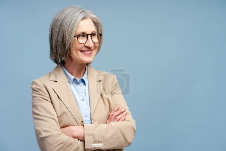 Photo for Confident smiling business woman, lawyer, financier wearing eyeglasses looking away isolated on blue background. Portrait of confident gray haired CEO holding arms crossed. Successful business - Royalty Free Image