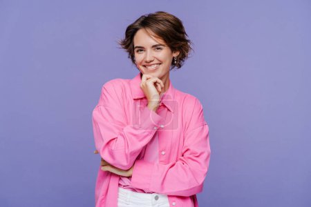 Photo for Portrait of beautiful woman wearing stylish pink shirt looking at camera, posing isolated on violet background. Fashion model concept - Royalty Free Image