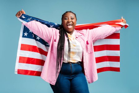 Téléchargez les photos : Portrait femme afro-américaine heureuse tenant drapeau américain fête de l'indépendance. Concept de liberté - en image libre de droit
