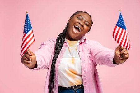 Téléchargez les photos : Portrait heureuse femme afro-américaine émotionnelle, partisane tenant des drapeaux américains en attente des résultats des élections. Vote, liberté, concept d'élection présidentielle - en image libre de droit