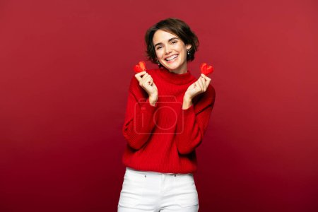 Photo for Happy romantic cute woman holding red hearts celebration Valentines day isolated over red background. Dating, love concept - Royalty Free Image