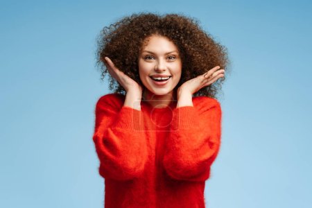 Photo for Cute beautiful young woman with curly hair looking at camera posing isolated on blue background. Concept of natural beauty - Royalty Free Image