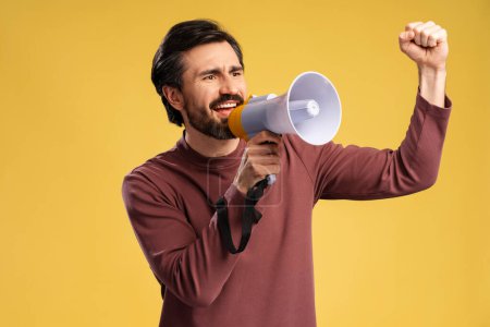Foto de Sonriente joven emocional haciendo anuncio con megáfono en las manos, fondo amarillo aislado. Compras, concepto de venta. Publicidad - Imagen libre de derechos