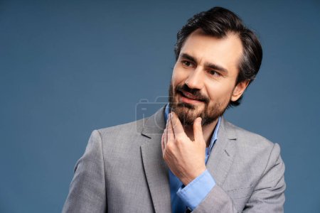 Photo for Businessman smiling with thoughtful face looking to the side isolated on blue background. Copy space. Achievement, career, business concept - Royalty Free Image