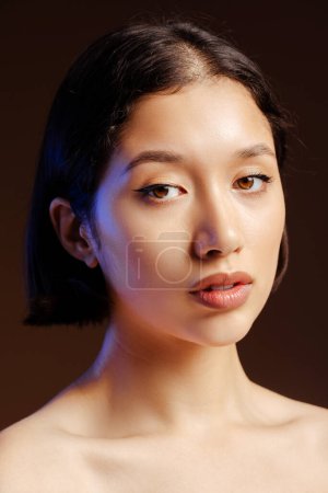 Téléchargez les photos : Closeup beauty portrait of dark-haired beautiful young woman, with fresh glowing healthy skin looking at camera, posing naked over isolated black colour background - en image libre de droit