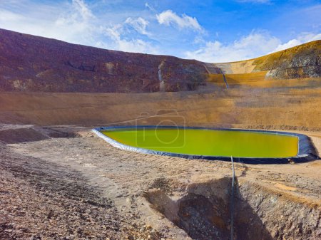 Geomembrane pool filled with rainwater at the bottom of an open mine pit.
