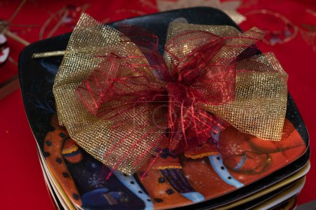 Foto de Christmas decorative gold ribbon on plates on table, holiday table setting concept - Imagen libre de derechos
