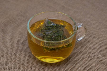Téléchargez les photos : Herbal tea infusion in glass cup - en image libre de droit