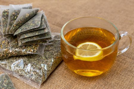 Téléchargez les photos : Herbal tea and bags on burlap - en image libre de droit