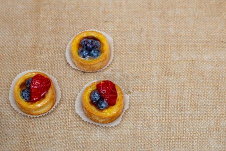 Photo for Delicious mini fruit tarts on natural burlap - Royalty Free Image