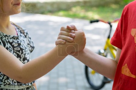 Niños tomados de la mano al aire libre, comunicación y concepto de amistad