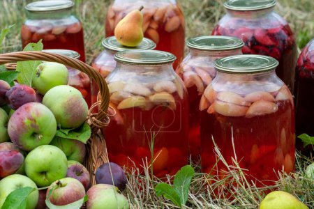 Foto de Frascos de compota de frutas conservadas para el invierno. Manzanas y peras en la cesta. - Imagen libre de derechos