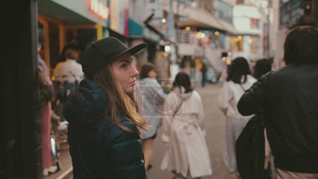 Femme blanche marchant le soir dans les rues de Tokyo. Attrayant voyage touristique fille Japon point de repère bénéficie de l'ambiance de la ville en vacances. Mode de rue, vie nocturne. Vue arrière