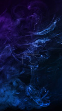 Téléchargez les photos : Vue des nuages de fumée de couleurs mixtes bleu et violet sur fond noir - en image libre de droit