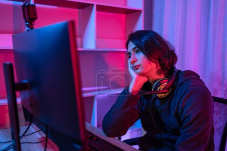 Photo for Handsome boy playing E-Sport game or streamer, Defeat or failure, Mistakes of managing a team in the game lead to defeat,  Live show play games, Blue and red lights. - Royalty Free Image
