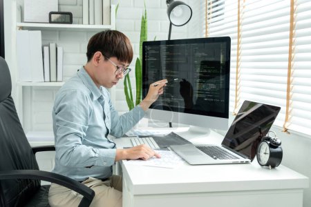 Photo for Male programmer is programming to develop program app and website of corporate while working to checking program code and debugging on multiple screen at modern software office. - Royalty Free Image