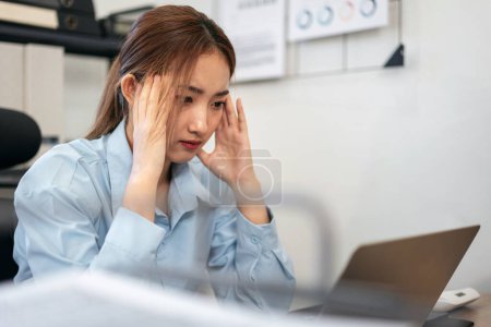 Photo for Businesswoman is feeling headache and stressful while reading information in laptop and thoughtful about accounting of business with working about new business project at modern office. - Royalty Free Image