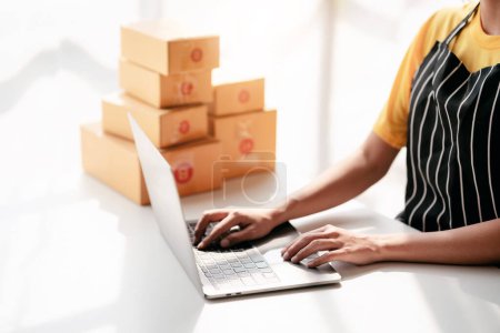 Photo for Small business parcel delivery concept, Female entrepreneur checking online order on laptop and packing product to shipment delivery for client while working about shopping online sales business. - Royalty Free Image