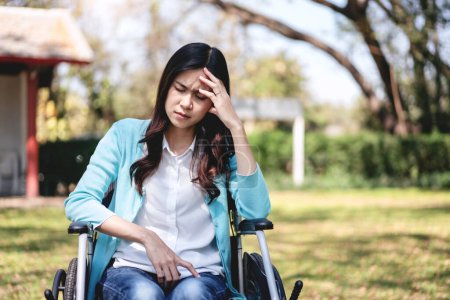Frau im Rollstuhl, junge Asiatin im Rollstuhl im Garten und Hände zum Nasenreiben, während sie sich gestresst und erschöpft fühlt.