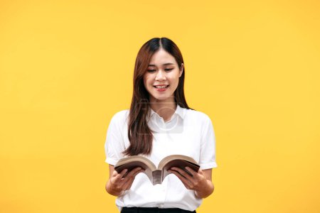 Photo for Young asian woman wearing white short sleeve shirt and holds holy bible to reading and praying to god about spirituality faith worship isolated over yellow background. - Royalty Free Image