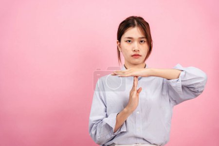 Photo for Young asian woman wearing long sleeve shirt and disappointed face while using both hands to showing time out gesture isolated over pink background. - Royalty Free Image