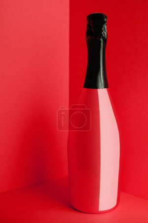 Botella roja de champán sobre fondo rojo