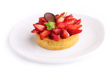 Tartlet with strawberry on white plate