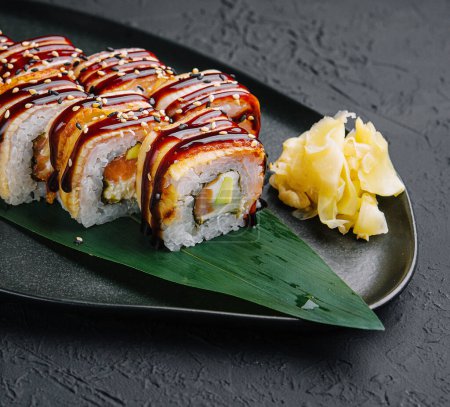 Sushi-Set Canada Roll mit Aal auf schwarzem Stein