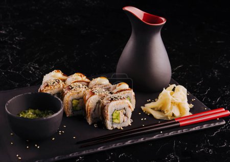 Sushi-Set Canada Roll mit Aal auf schwarzem Stein