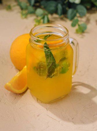 Téléchargez les photos : Citronnade avec des tranches d'oranges fraîches et menthe dans une cruche en verre - en image libre de droit