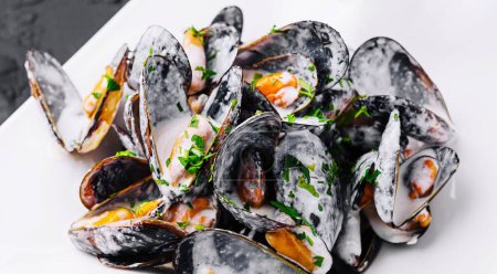 Plate of tasty mussels with parsley close up