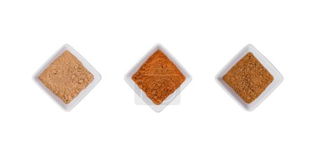 Various Indian Spices in Small White Bowls on white background