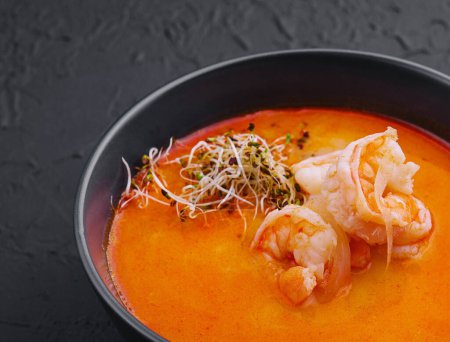 Photo for Traditional Thai soup Tom Yam in black bowl - Royalty Free Image