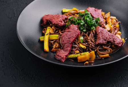 Chinesischer gebratener Reis mit Rindfleisch auf schwarzem Teller