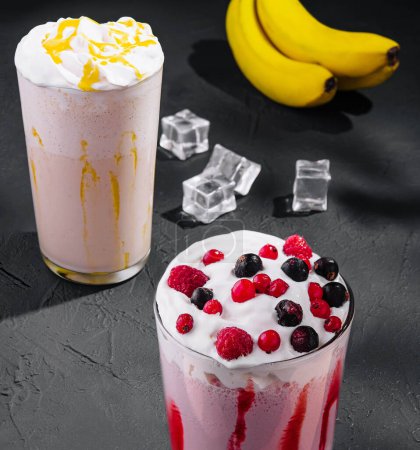 Photo for Delicious milkshakes on black stone with ice cubes - Royalty Free Image