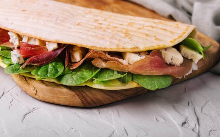 Photo for Piadina - classic Italian tortilla-bread with prosciutto, basil and dor blue - Royalty Free Image