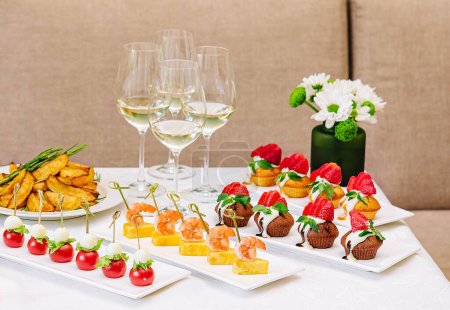 Tisch mit verschiedenen Gourmet-Snacks für Weißwein