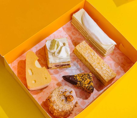 Assorted Cake Slices in Yellow Gift Box on Yellow Background