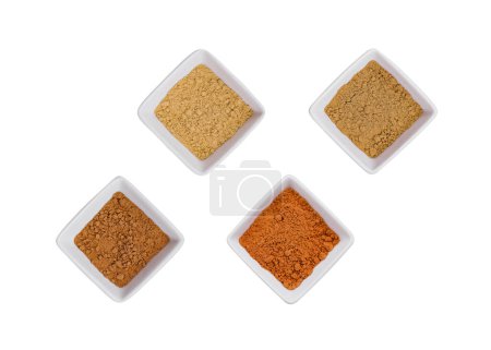 Various Indian Spices in Small White Bowls on white background