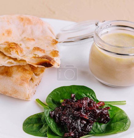 chicken pate with onion jam and pita bread served in a white plate
