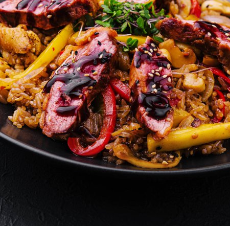 Chinesischer gebratener Reis mit Rindfleisch auf schwarzem Teller