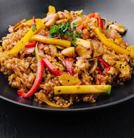 Chinesischer gebratener Reis mit Gemüse auf schwarzem Teller