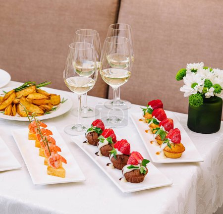 table with different gourmet snacks for white wine