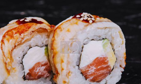 canada roll with salmon on black stone