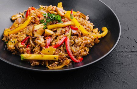 Chinesischer gebratener Reis mit Gemüse auf schwarzem Teller