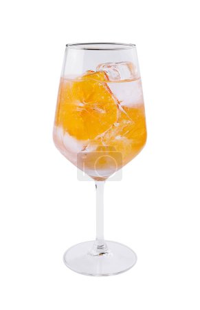 Crystal wine glass filled with a vibrant orange beverage and ice, isolated on white